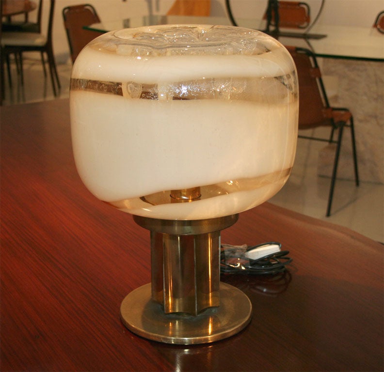 Brass based table lamp with a swirled glass globe. Top of globe has Vistosi stamp on it.