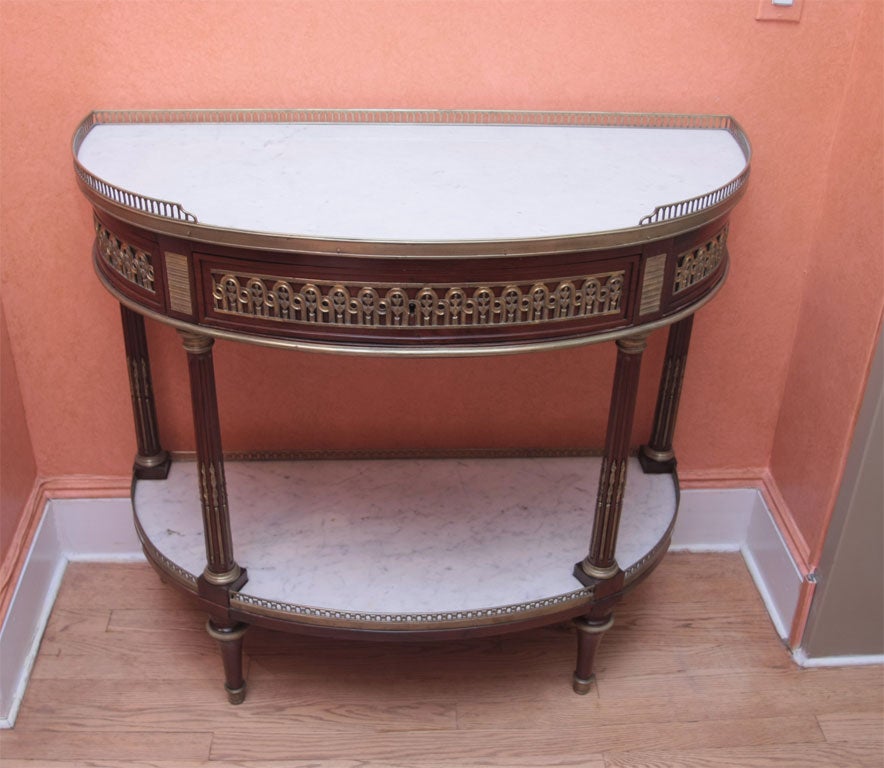 A mahogany, gilded bronze and white marble demi-lune console