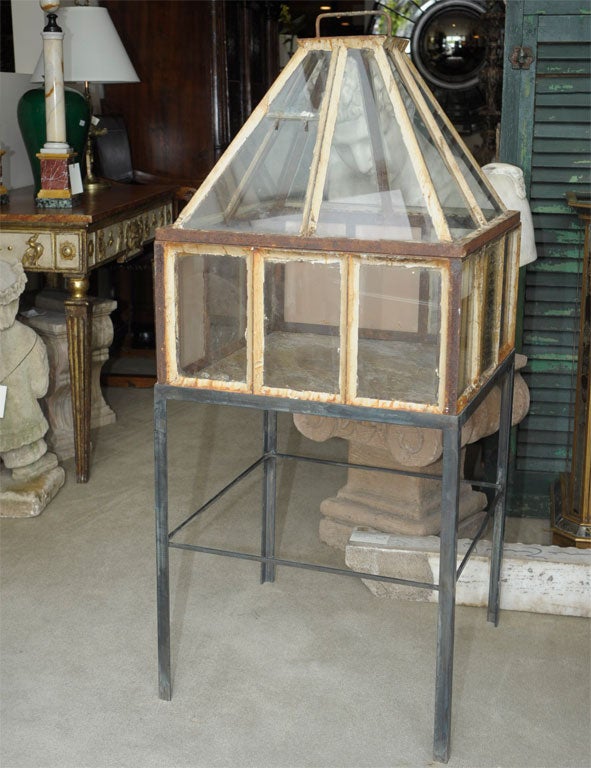 A very interesting iron and glass cloche made in France early in the 20th century.  These where used to protect young plants from late frosts.  We have two available, priced separately.  The iron stands and slate bases are later.  These could also