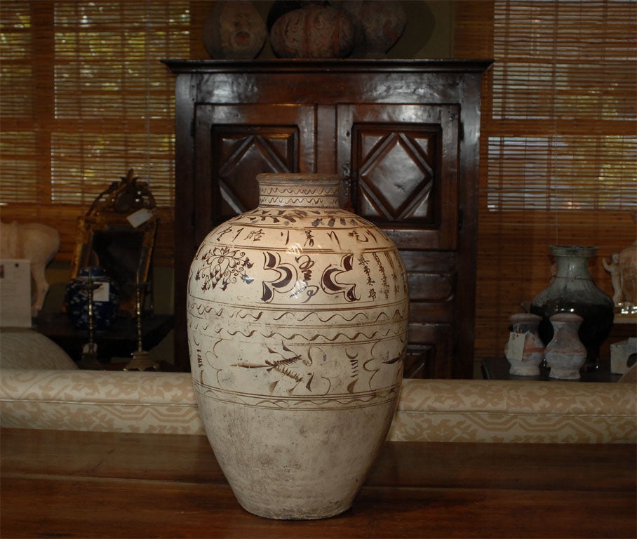 Dark brown markings with transparent glaze. Markings symbolize the phoenix and other decorative motifs possibly denoting maker of rice wine. These were storage vessels for wine and also used to transport wine.