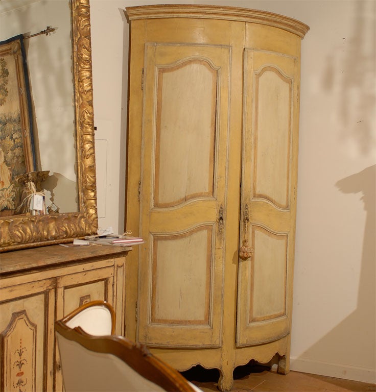 Two French 18th century Rococo painted wood corner cabinets from Provence with molded doors and scalloped skirts, priced and sold individually. Born in the exquisite southern French region of Provence during the Age of Enlightenment, each of these