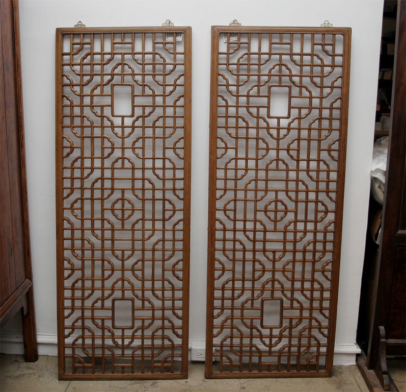 Vertical Chinese wood screen, window panels with a floral pattern.