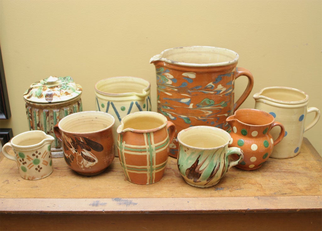 Nine pieces of French country jaspe pottery from a larger collection.  This pottery originates from the Savioie region of France and dates from the late-19th to the early-20th century,.  The traditional glazed treatments, called jaspe, are usually