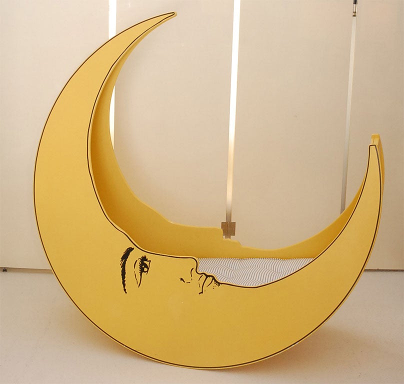 This limited edition cradle, based on a magazine holder, is number 7 of 20. It is transfer printed with the smiling face of the crescent moon.  The mattress and pillow have been newly made.  although made with a baby in mind, this would make the