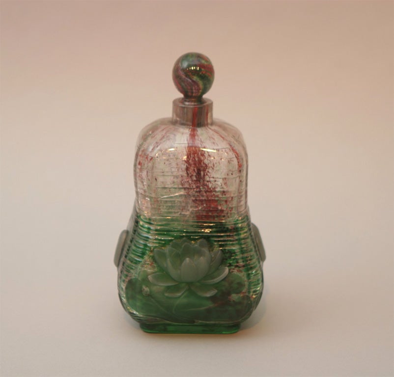 a rare and fine signed Eugene Michel cameo glass bottle and stopper, the body with applied lotus flowers and buds on all four sides, the inside glass with mottled red and green, signed E. Michel