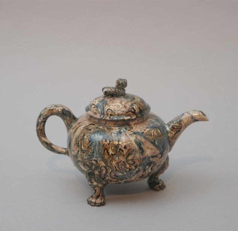 A rare and fine English solid agate pottery footed teapot molded with three lion's head and paw feet and Chinese lion finial