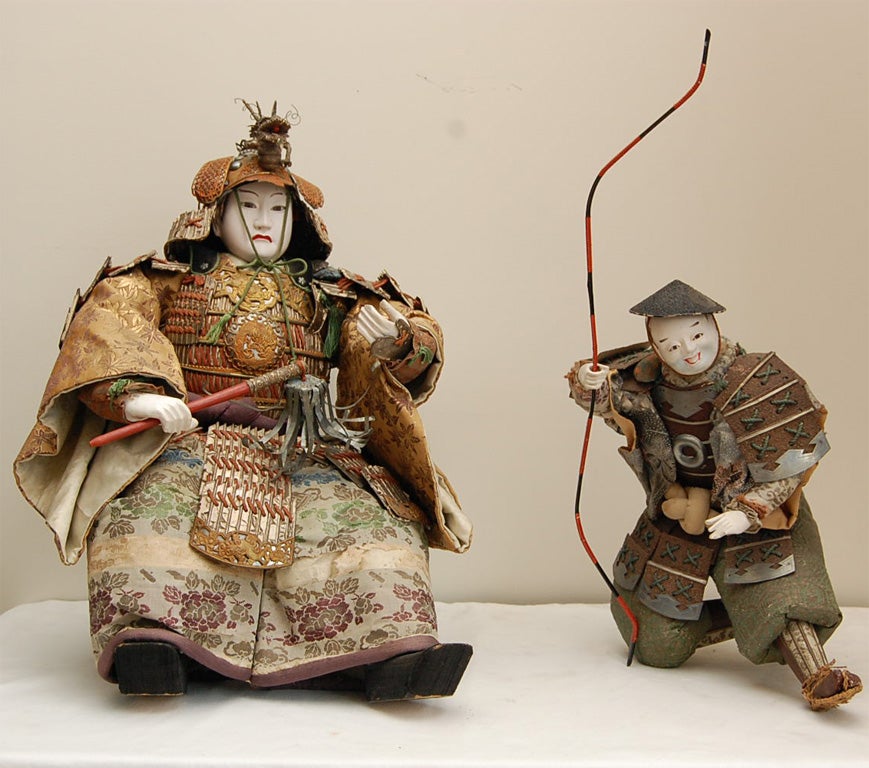 Two Dolls. This Busho (head of Samurai) doll is the legendary warrior Minamoto no Yoshitsune (1159-1189) with an attendant. His story is very popular in Noh and Kabuki plays and very often the warrior model of the Boy's Day tradition.