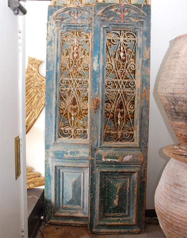 Grand pair of antique French blue colored painted doors with inset ironwork detailing.  The backs are painted an Italian green.  These doors could be amazing worked into the construction of a home.  They also make great decor by standing them alone
