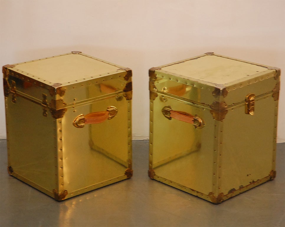 Pair  of  polished  brass  trunks   with leather handles and stud  detailing.   Lots of patina and perfect  for night stands.   Each trunk opens up for great storage.