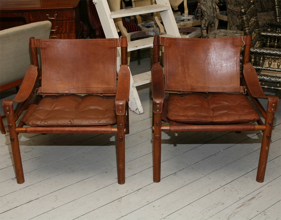 Pair of chairs called 'Sirocco' chairs by Swedish designer, Arne Norell, in burnt brown <br />
leather, nice old patina, mid-century  modern.