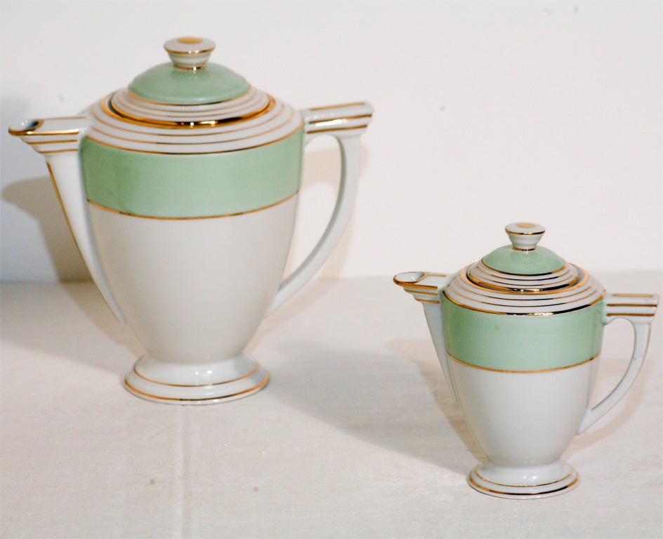 Classical form Limoges Art Deco tea service with tea pot, creamer, sugar and 8 matching diminuitive cups and saucers. Celadon green, pure white and gold embellish this lovely set.