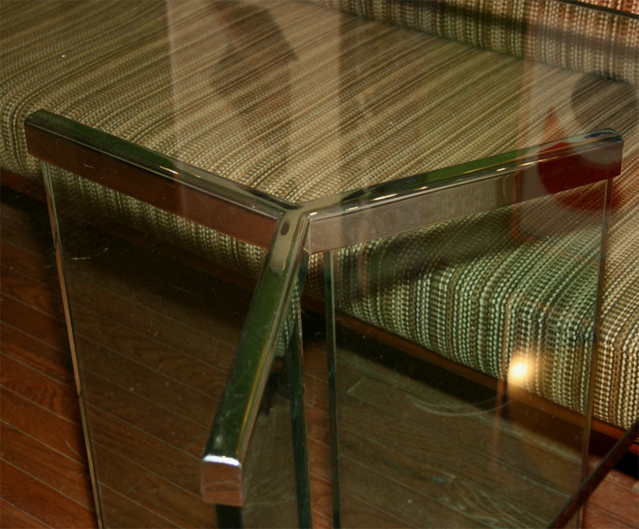 2 pedestals, each one made of 3 thick glass panels point together with a chromed structure metal base