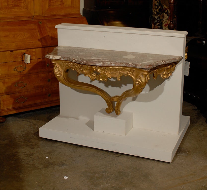 Ein vergoldeter Konsolentisch aus der Zeit Ludwigs XV. mit durchbrochener Schürze, serpentinenförmig mit passender originaler Marmorplatte. In der ersten Hälfte des 18. Jahrhunderts in Frankreich entstanden.