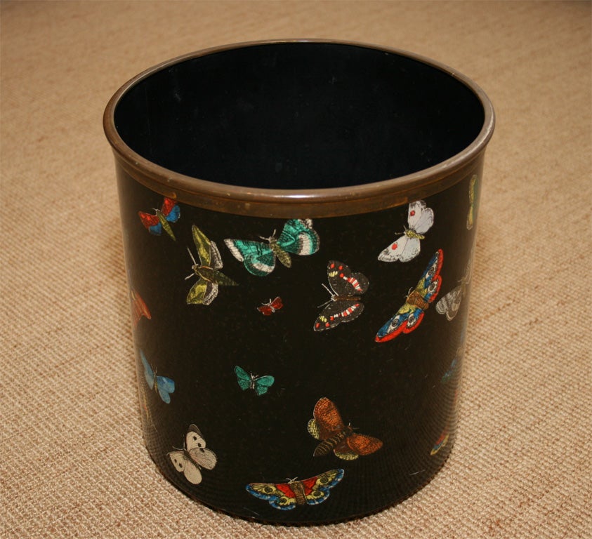 The cylindrical metal body, decorated with colorful printed butterflies on a black ground, a brass rim and studs. Printed makers stamp.
