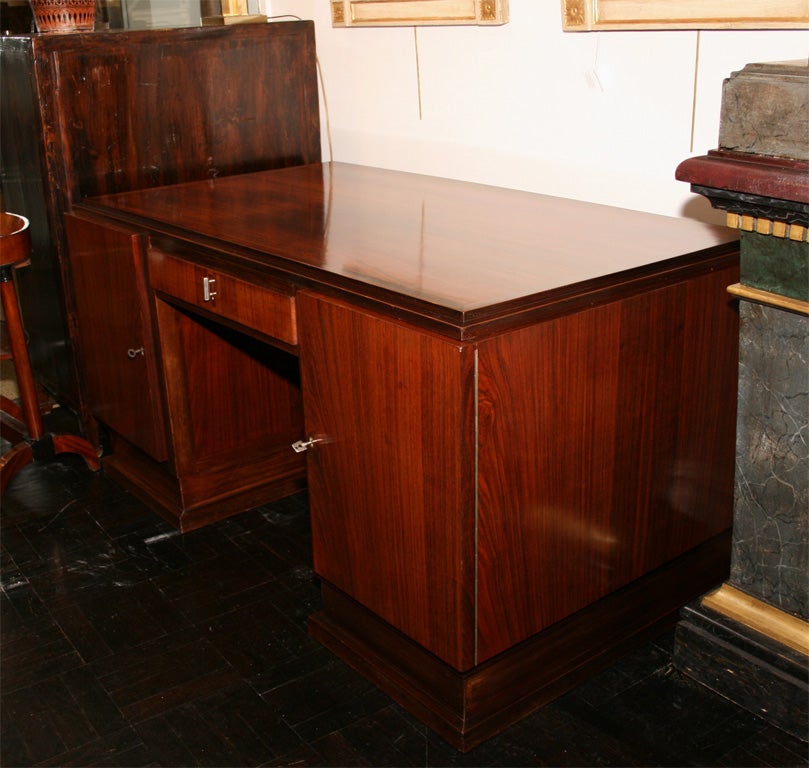 20th century rosewood desk, polished top, above one drawer and two side doors, stepped base.