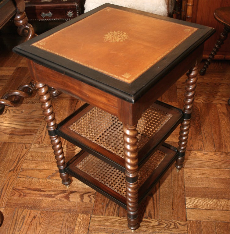 Pair of Napoleon III Mahogany and Ebonized Three-Tier Tables with Barley Twist Supports; Each Table with Two Caned Lower Shelves, One Drawer (see image 3)and Later Gold-Tooled Brown Leather Tops, France, Late 19th Century<br />
<br />
28 inches
