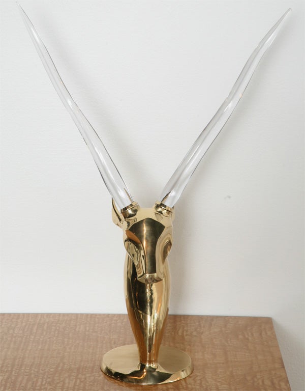 Polished heavy cast brass antelope head fitted with glass horns. A fascinating use of materials. It's identical to one that made an appearance in the movie 