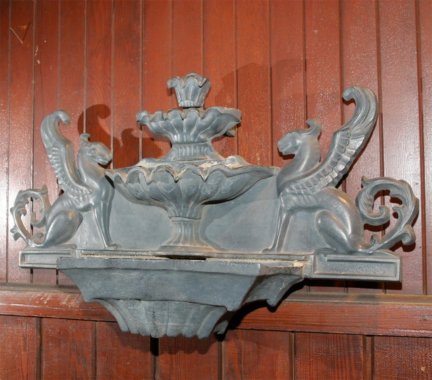 Three tiered cast iron fountain adorned with griffins.