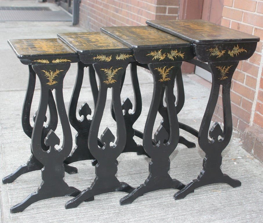 An extremely fine set of 4 antique  China trade graduated nesting tables.  Dark lacquer with gilt and penwork decoration depicting fiqures in a scene. Some craqueleur to lacquer, but decoration in excellent condition.