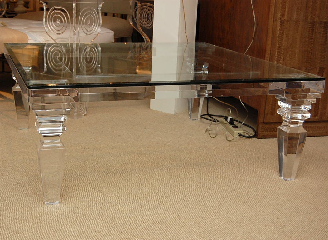 Beautifully carved lucite cocktail table with glass top. The glass has a 1 inch bevel