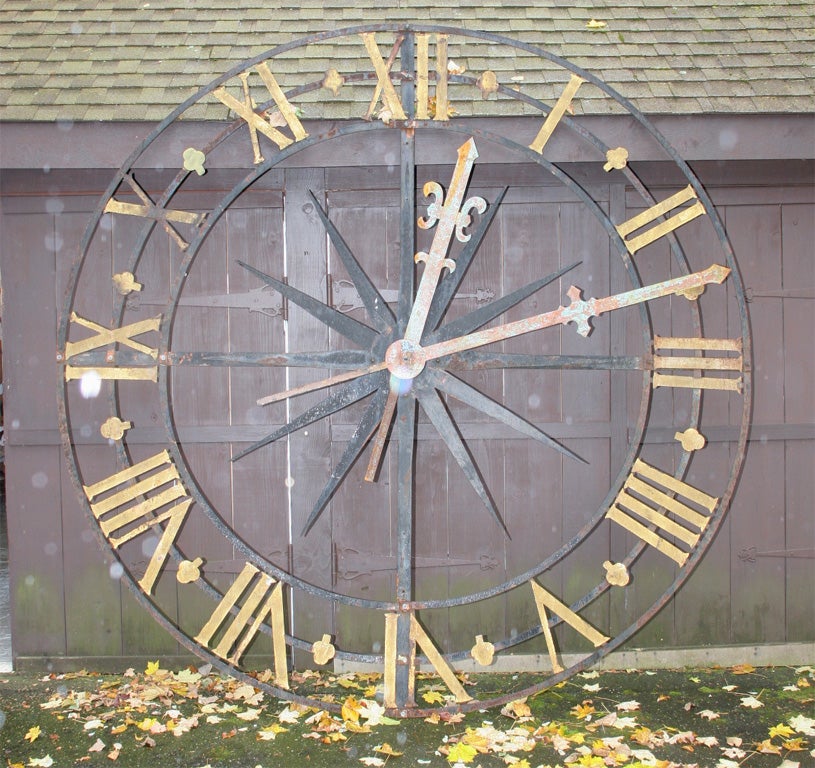 Metal skeleton style clock tower, clock face, with starburst motif.<br />
Original gilding on numerals.