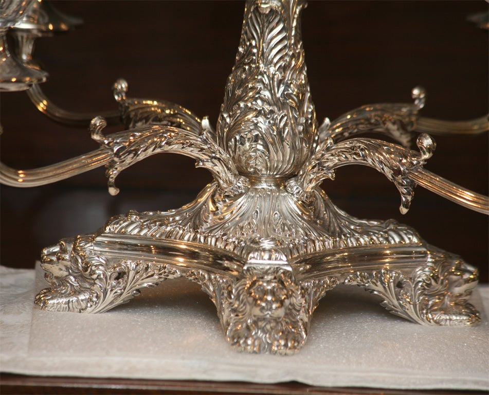 Spectacular 19th century English silver plated epergne with figural lion's head feet and chased silver arms and base. The handblown crystal center bowl is petal cut and frosted with 4 matching smaller bowls surrounding the raised center. This piece