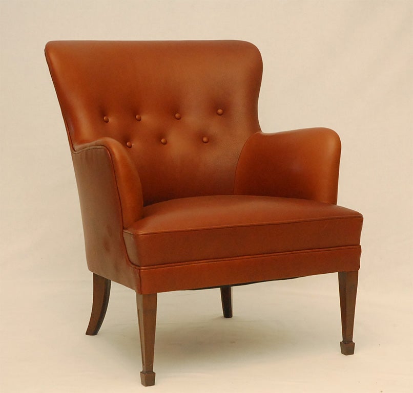 Fauteuil Frits Henningsen en cuir brun.  Magasin anciennement connu sous le nom de ARTFUL DODGER INC