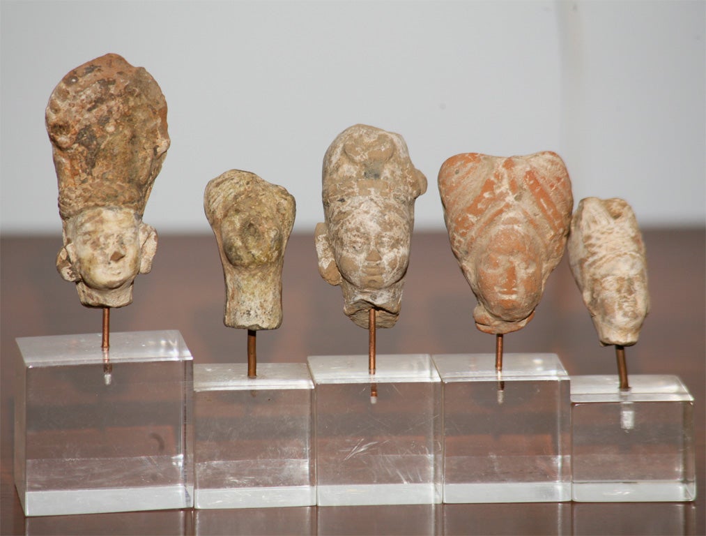 A set of 5 pottery busts mounted on lucite stands, with traces of polychrome.  Greco-Buddhist art is the artistic manifestation of Greco-Buddhism, a cultural syncretism between the Classical Greek culture and Buddhism, which developed over a period