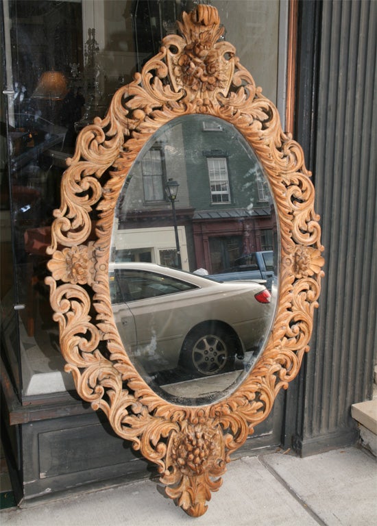 This very large and impressive mirror is typical of the early Victorian period. The deeply carved frames design elements include flowers, grape clusters, shell work, stylized acanthus leaves and a very nice inner border of gadrooning. The frame is