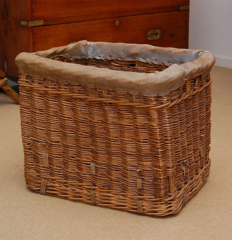 A Turn-of-the-Century Wicker Laundry Basket with original vellum leather edging.  Perfect size for holding magazines or kindling wood.<br />
CONTACT US FOR<br />
SPECIAL DEALER PRICE.