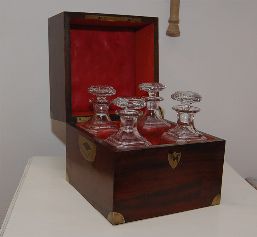 An early 19th Century Mahogany Decanter Box with four original glass decanters, original hardware, key and lock.  Originally used by traveling French military officers.