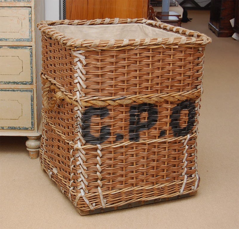 A large French turn-of-the-century Laundry Wicker Basket with original vellum leather binding and original paint.  Wonderful for holding firewood.
