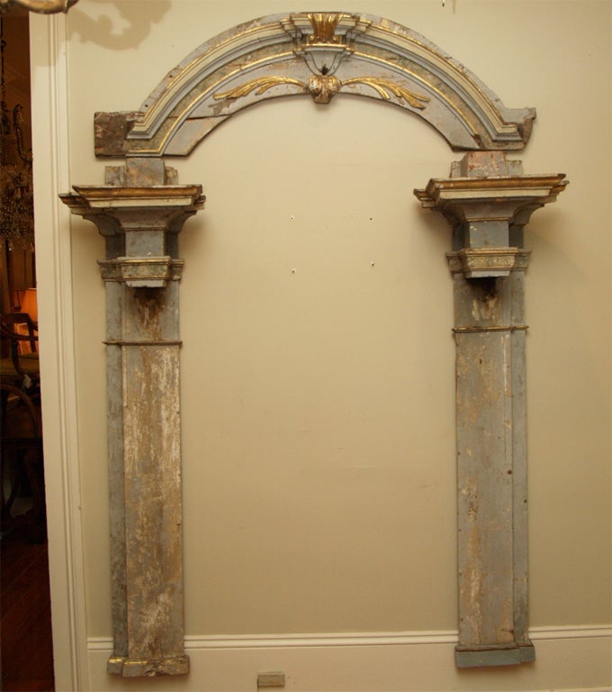 Gilt and faux marbled door frame consisting of an arched top and heavily molded columns.