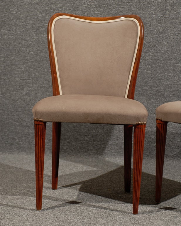 Mahogany and flame birch dining chairs upholstered in stone gray Ultrasuede with cream leather double welt.