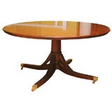 An exceptional hand made mahogany round dining table with semi-circular leaves.