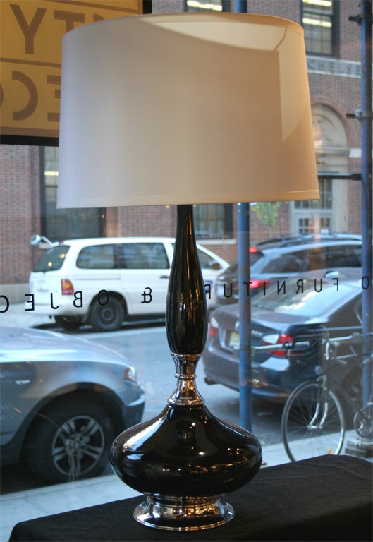 This beautiful Mid-Century Modern ceramic lamp was realized in the United States, circa 1960. It features an organic protuberant form finished in a lustrous black glaze that extends upwards from a chrome base. Elegant, whimsical and dramatic, this