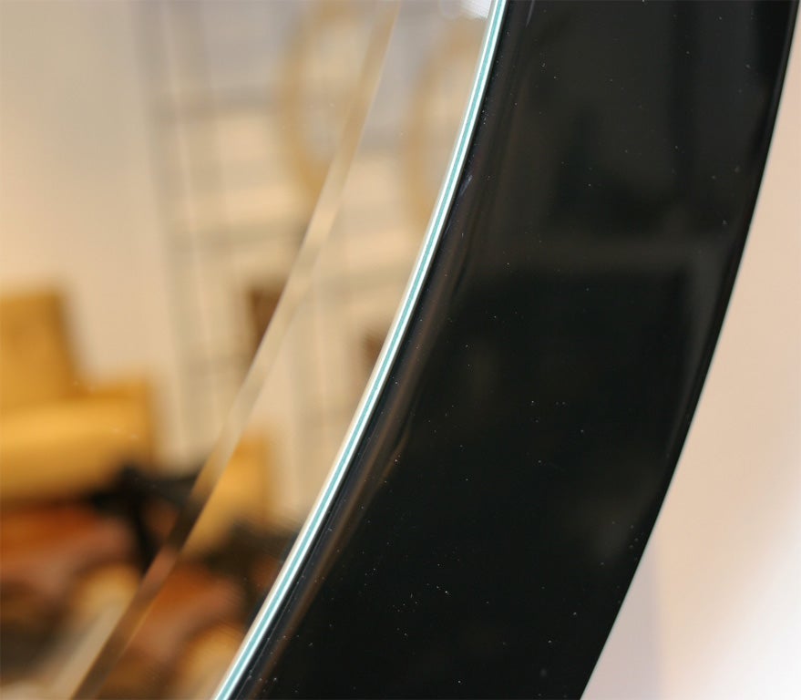 A classically sculpted walnut frame encircles a beveled mirror. Frame is 3