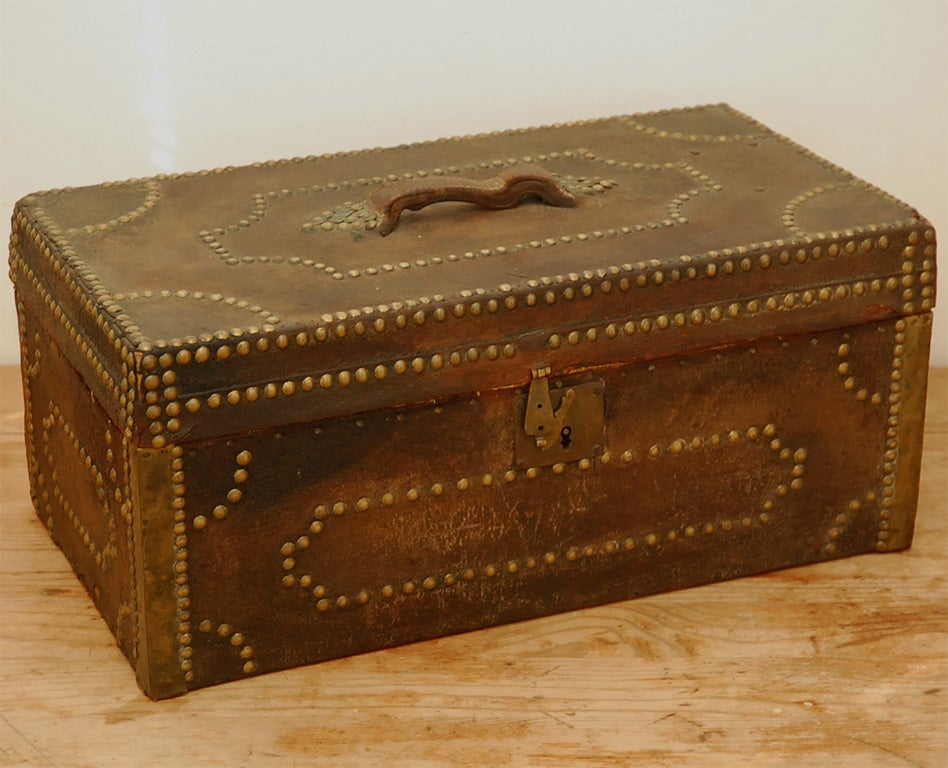 This is a terrific decorative object. It's a c. 1840 American stagecoach leather trunk complete with all original brass nailheads (some are missing). The trunk is wood covered in leather and decorated all over with brass nailheads. It has a handle