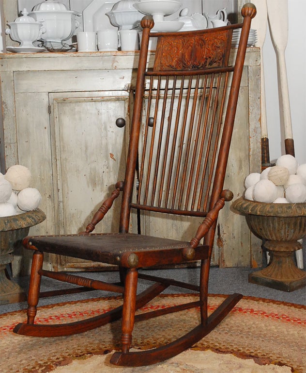 RARE AND UNUSUAL HICKORY AND LEATHER SEAT AND INSIDE BACK PRESSED BACK LEATHER AND WOOD ROCKING CHAIR. THIS GREAT ROCKER HAS BRASS BALL FINIALS AND BRASS BALLS ATTACHED TO SIDES. THIS IS ALSO VERY COMFORTABLE AND HAS A GREAT RUSTIC LOOK.