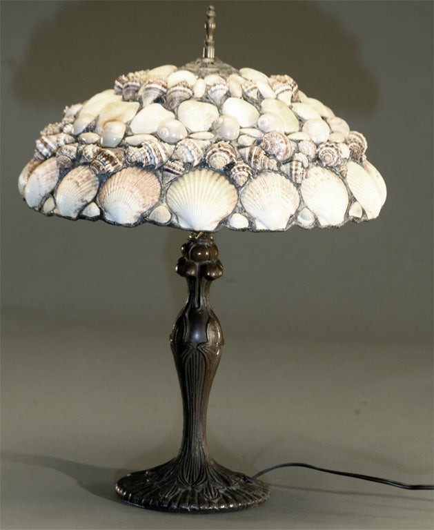 This Art Nouveau stylized lamp has a patinated metal base with beautifully constructed shell lamp shade, each shell mounted with leading in a mosaic motif. Beautiful when lit and a true work of art unlit as well.