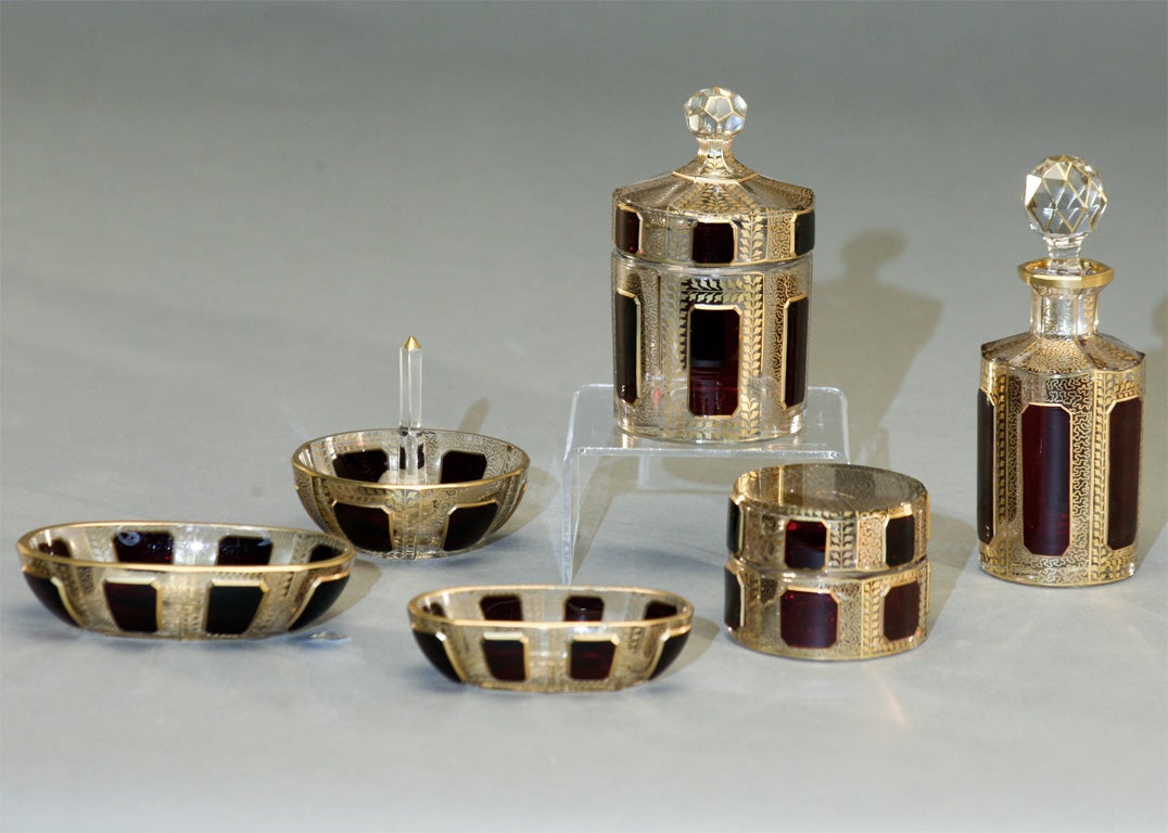 Wonderful complete dresser set of hand blown crystal, ruby overlay, cut to clear and hand painted gold enamel decoration. Set includes a perfume bottle, covered large box, smaller round box, 2 oval pin trays and the ring holder.