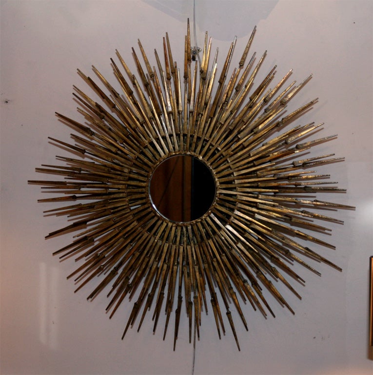 Gilt decorated bronze sculptural sunburst mirror, the sculptural pieces making up the mirror are in the shape of nails joined together, American, 1970's<br />
35