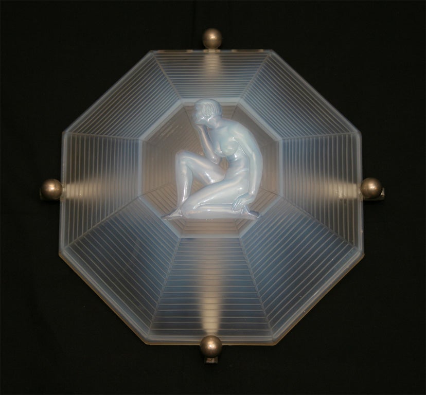 A French Art Deco octagonal ceiling fixture or wall sconce from circa 1925 by Henri Dieupart, in frosted glass with a central molded decoration representing a nude kneeling female figure in relief.