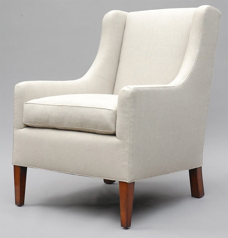 The Alfie by Lee Stanton Editions is an armchair with traditional yet modern lines. Featuring tapered wood feet, the chair is upholstered in a cream-colored Belgian linen (or custom fabric) and includes a 25/75 down envelope and foam core insert.