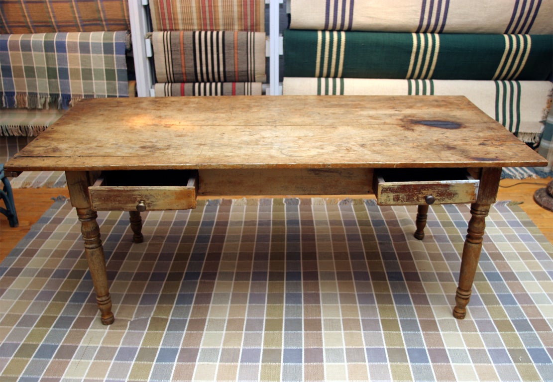 Old mustard paint.  Two-drawers, boldly turned legs.