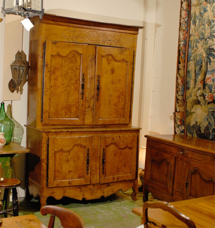 A French Provincial Buffet deux Corps constructed in beautiful figured burled elm, with elegant formed paneled doors, and a flower vine carving on the apron. All resting on short cabriole legs. 