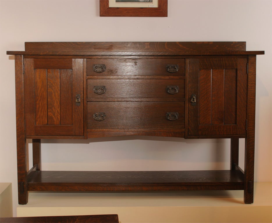 Mission Oak sideboard having three drawers and two outer chamfered cabinet doors.bottom strecther and hammered copper hardware.<br />
<br />
Also known as the Grand Rapids Chair and Bookcase Company.