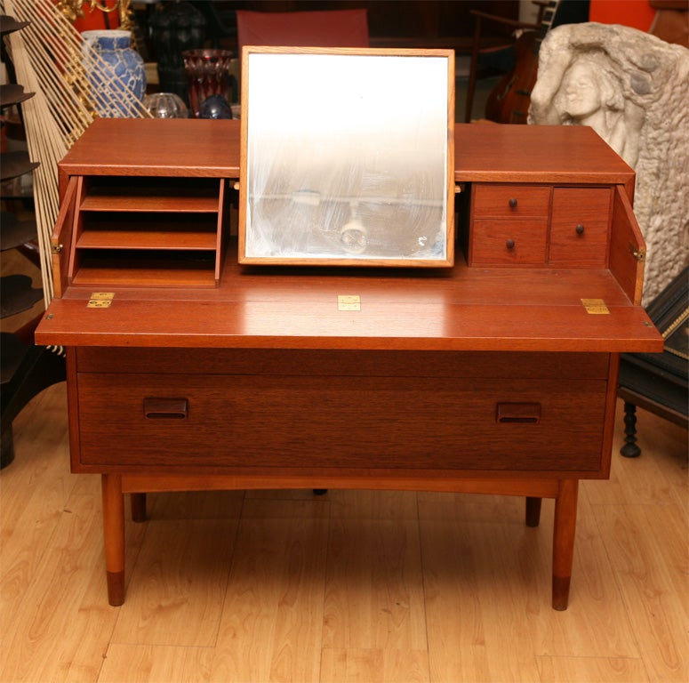 Three drawer chest in teak by Borge Mogensen, Danish Modern mid-century designer, top drawer pulls out to expose secretary with sliding mirror for batchelor or lady's use.
