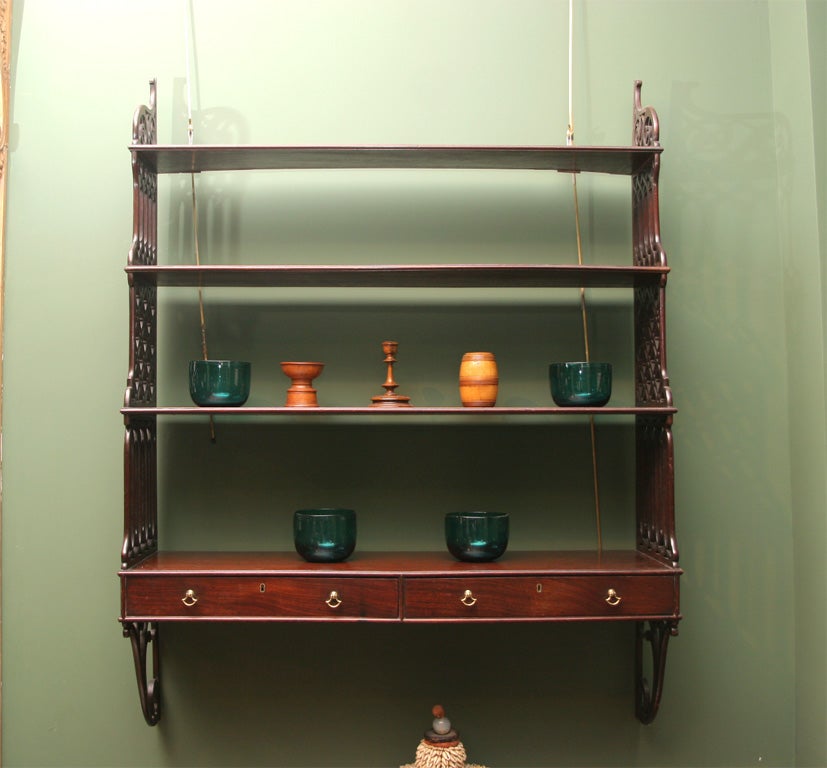 A very fine George II hanging shelf with open fret sides of varied designs, graduated in height and depth, having two drawers.  <br />
Similar to shelves made by Ince and Mayhew and Thomas Chippendale.