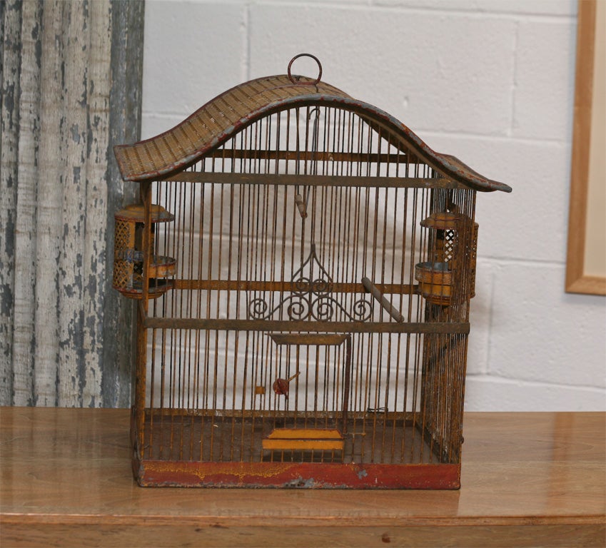 Charming painted iron birdcage with rusted patina.<br />
Gridiron top with feeders and hinged door. Swing.